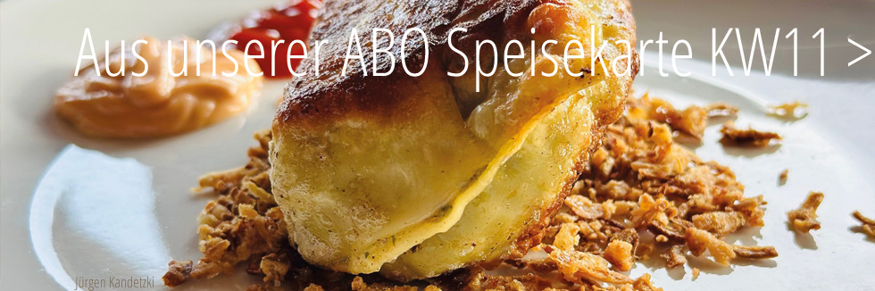 wir sehen einen weißen Teller mit einer cross angebratenen Maultasche, gebettet auf Röstzwiebeln