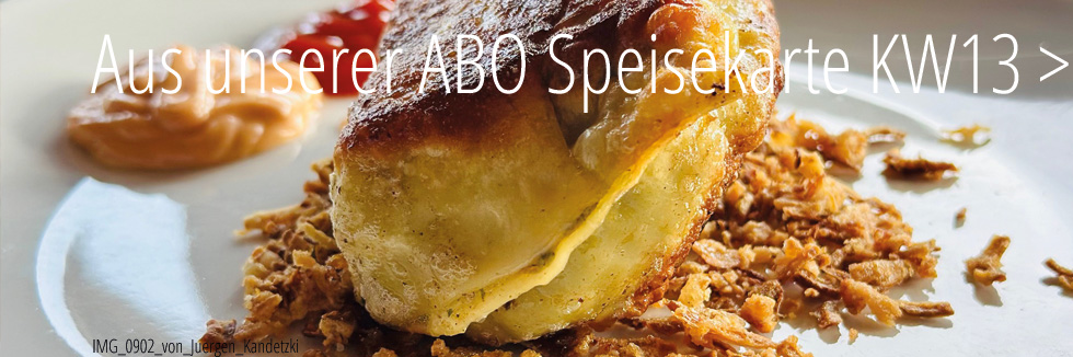 auf einem weißen teller sehen wir eine cross gebratene Maultasche gebettet in röstzwiebeln