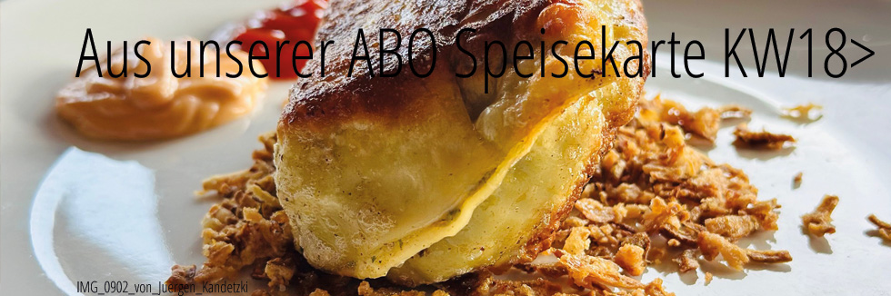 auf einem weißen Teller sehen wir eine braun gebratene Maultasche mit Röstzwiebeln